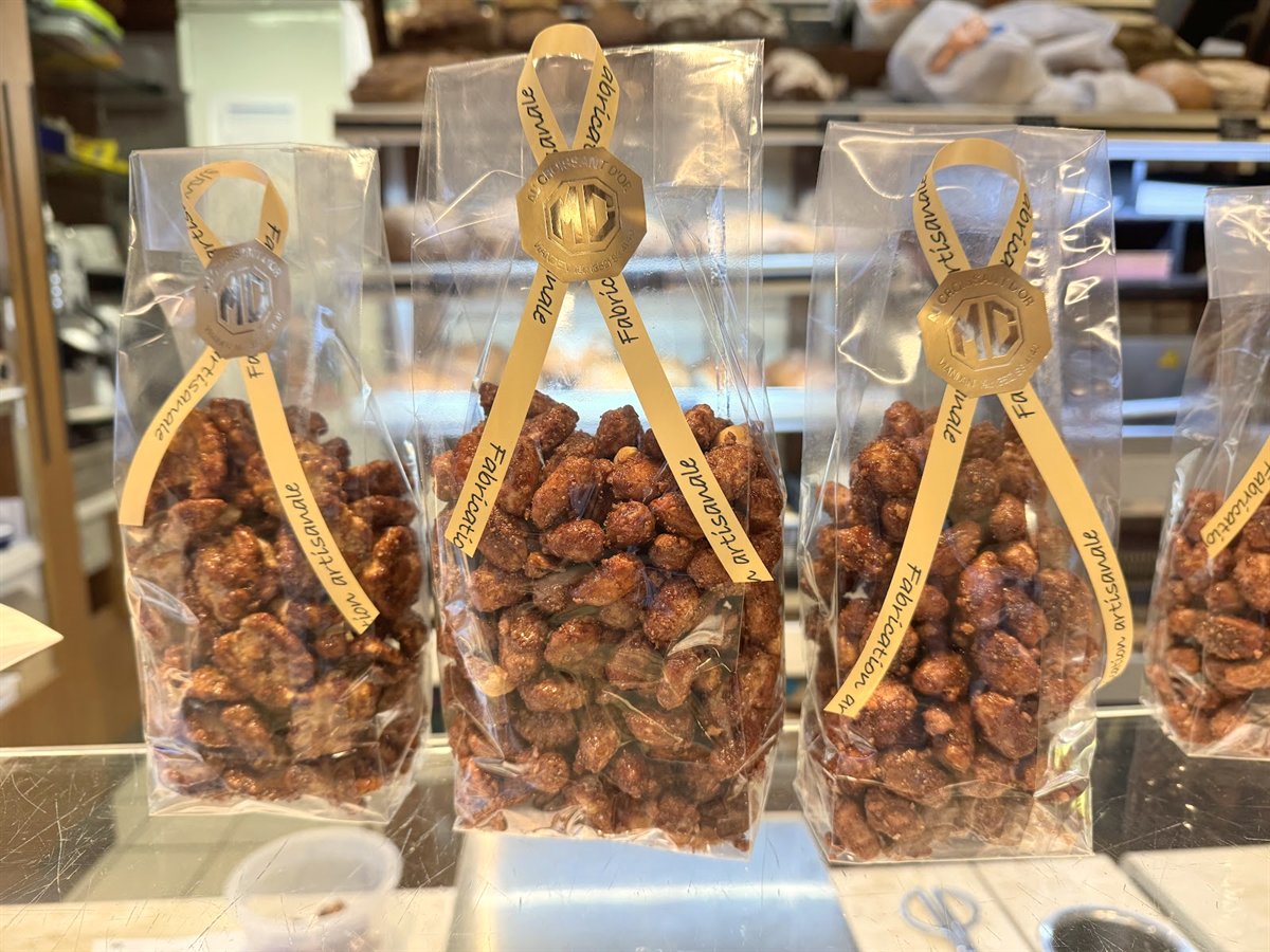 Bags of artisan roasted almonds tied with gold ribbon