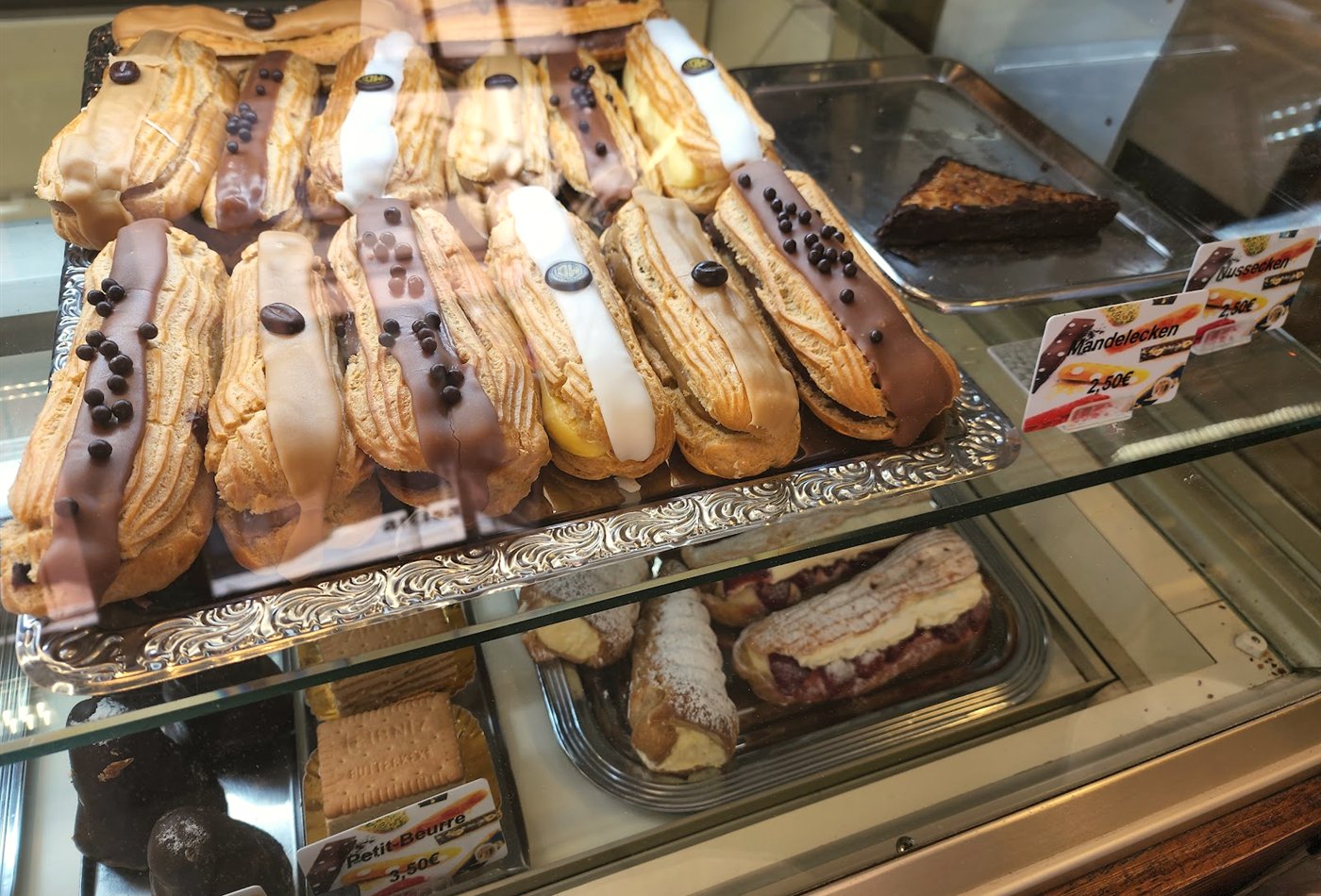 Display case of eclairs and cakes at the bakery counter