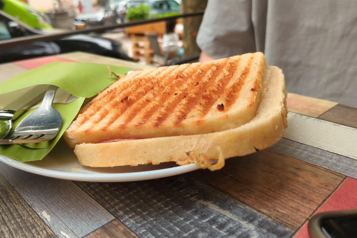 Grilled ham and cheese sandwich on a terrace table